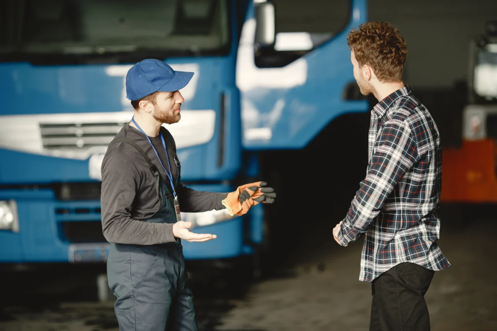 two guys talking about work work garage near truck transfer documents with goods